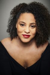 A headshot of a black woman looking at the camera