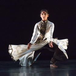 A woman in a white dress doing Kathak dancing