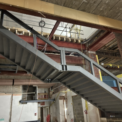 A large metal staircase going up through the middle of a building