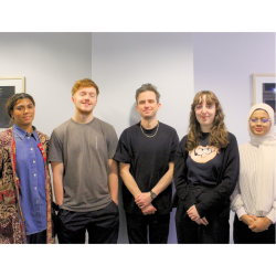 A group of 5 people stood smiling at the camera