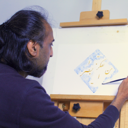 A photo of a man doing calligraphy