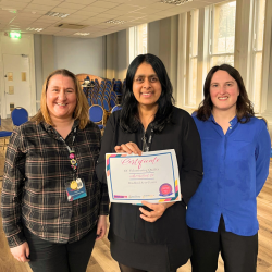 A picture of 3 people holding a certificate