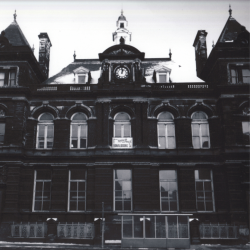 A old photograph of a large grand building covered in black soot